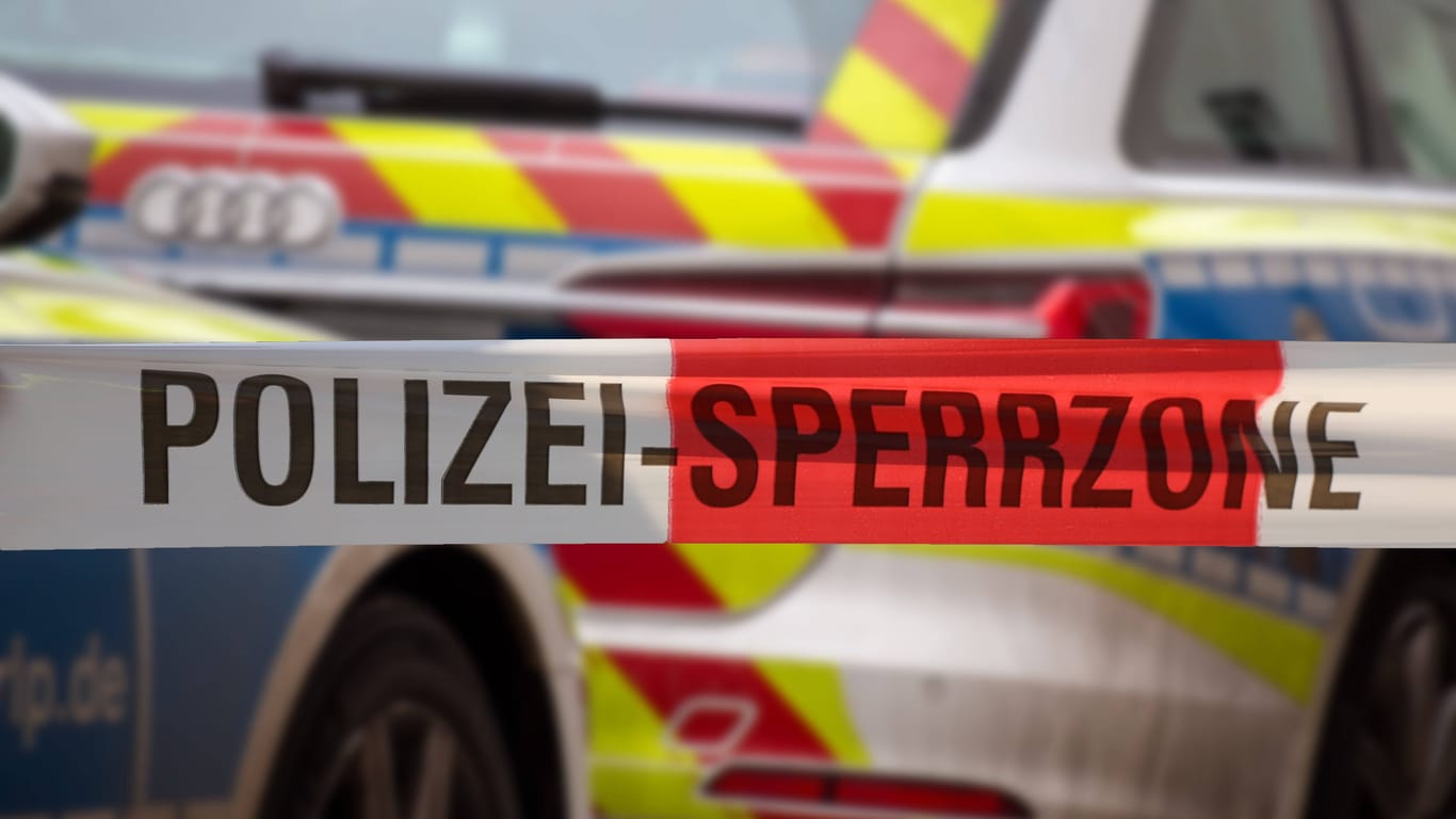 Polizeiabsperrung mit Polizeiauto im Hintergrund (Symbolbild): Die Frau des mutmaßlichen Täters schwebt nicht mehr in Lebensgefahr.