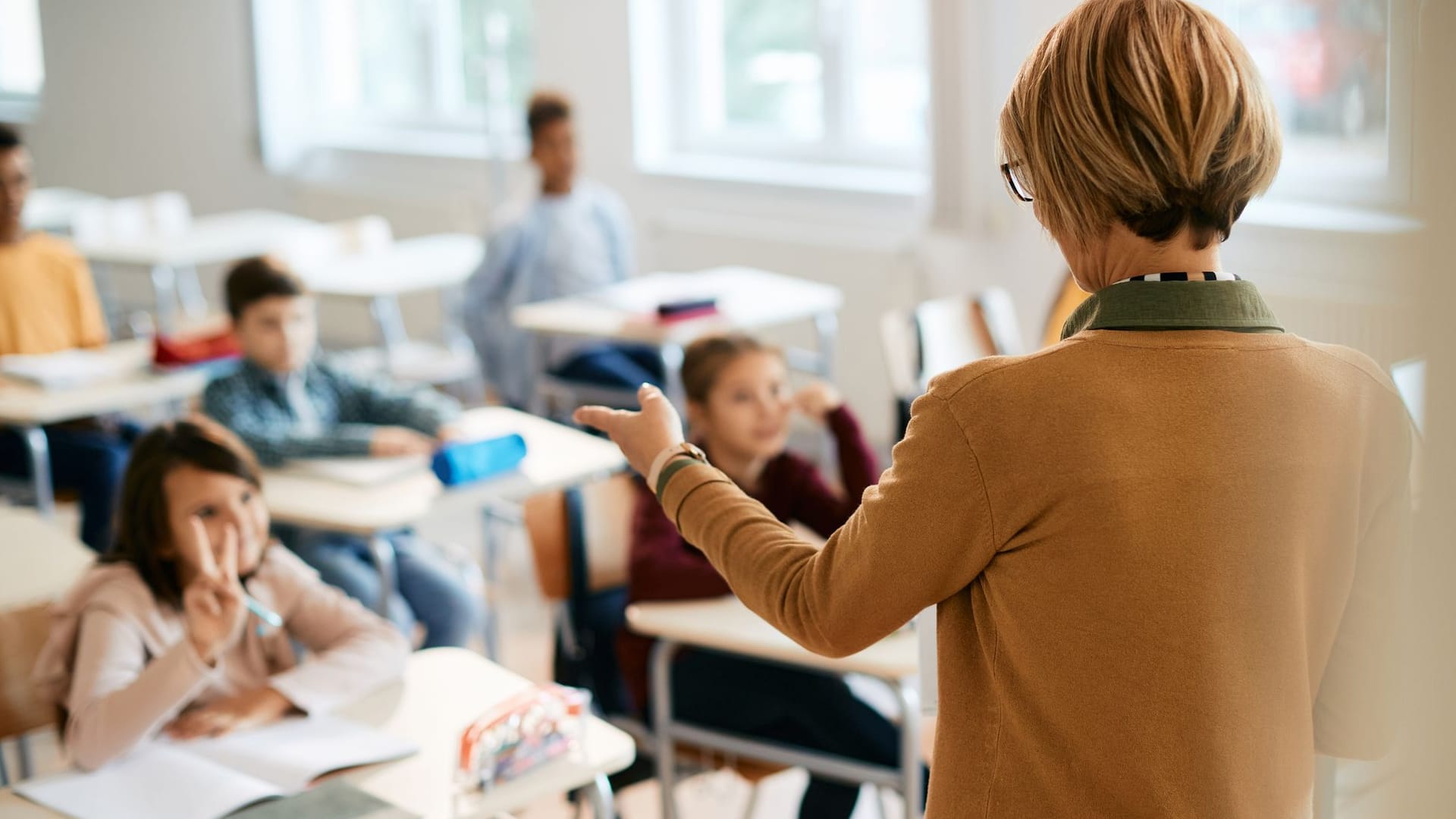 Lehrerin unterrichtet Schulklasse. Das Lehrer-Gehalt ist von verschiedenen Faktoren abhängig.