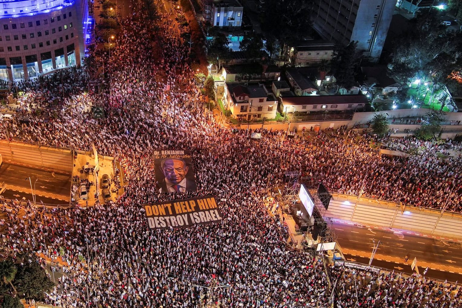 Luftaufnahme von der Demonstrationen in Tel Aviv: Ein Transparent zeigt den israelischen Ministerpräsidenten Benjamin Netanyahu samt der Aufschrift "Helft ihm nicht, Israel zu zerstören".