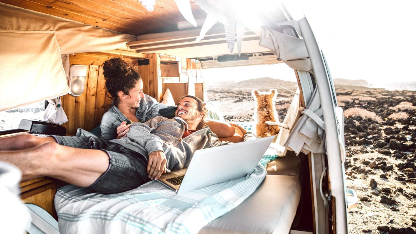 Ein Pärchen im ausgebauten Camper-Van: Zum kleinen Zuhause auf Zeit umgebaut, hat der klassische Kleintransporter viele Fans.