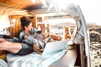 Ein Pärchen im ausgebauten Camper-Van: Zum kleinen Zuhause auf Zeit umgebaut, hat der klassische Kleintransporter viele Fans.