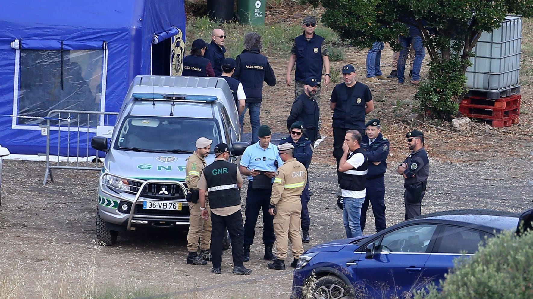 Polizisten unterhalten sich an einem Einsatzzelt in der Nähe von Barragem do Arade (Portugal): Deutsche und portugiesische Behörden haben eine neue Suchaktion im Fall "Maddie" gestartet.