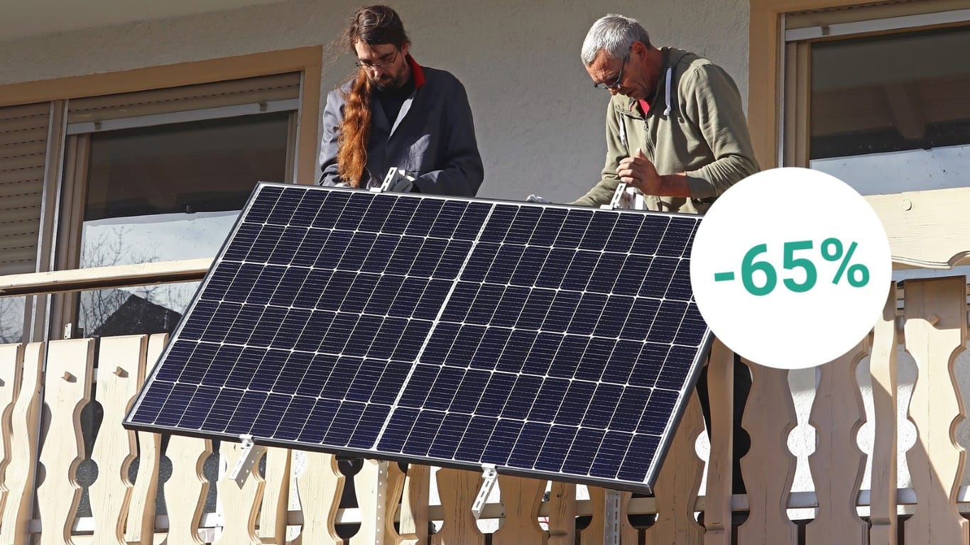 Zwei Männer montieren ein Balkonkraftwerk: Bei mehreren Händlern können Sie sich aktuell Solaranlagen für zu Hause mit starken Rabatten sichern.
