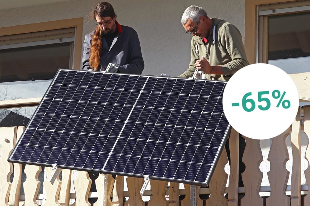 Zwei Männer montieren ein Balkonkraftwerk: Bei mehreren Händlern können Sie sich aktuell Solaranlagen für zu Hause mit starken Rabatten sichern.