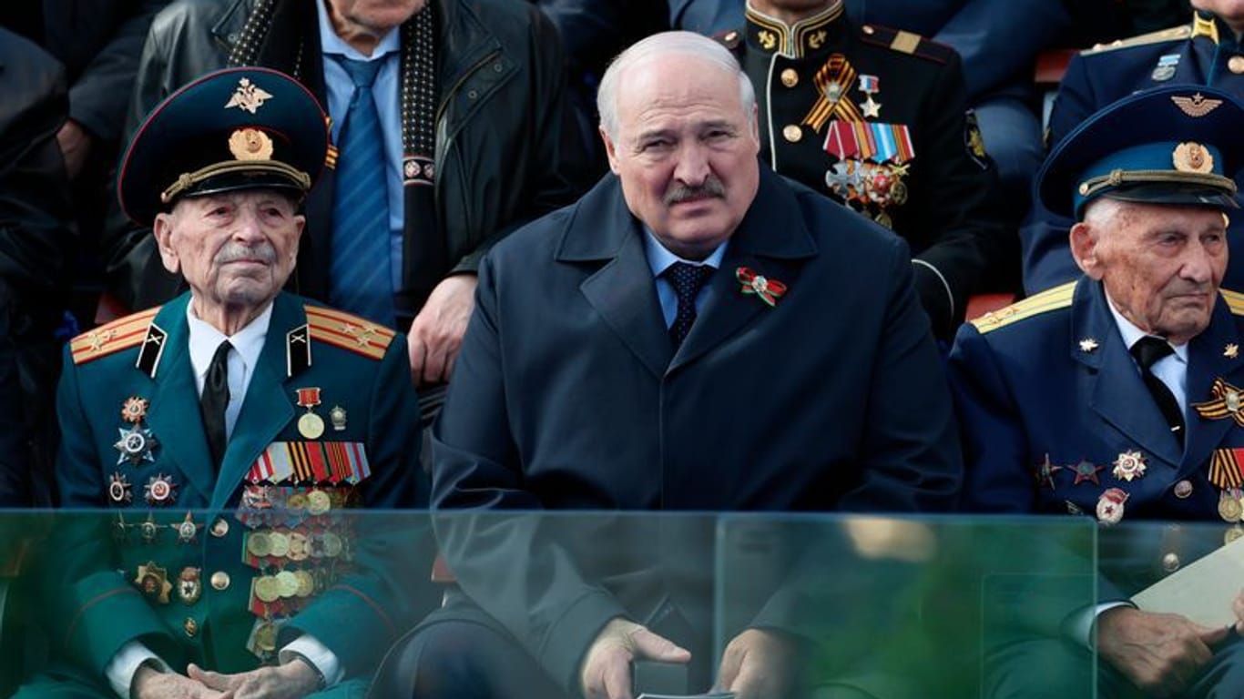 Nicht in Minsk: Der belarussische Präsident Alexander Lukaschenko (M) beobachtet neben Veteranen die Militärparade zum "Tag des Sieges" in Moskau.