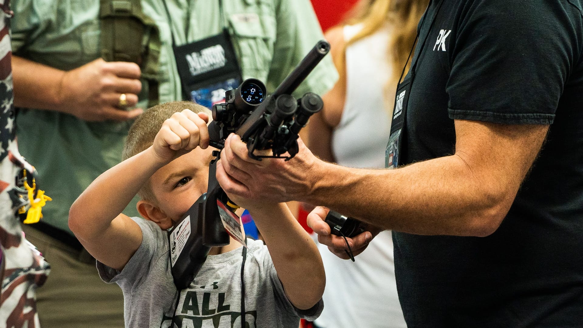 Waffenmesse in Indianapolis im April 2023: Ein Aussteller zeigt einem kleinen Jungen, wie ein Sturmgewehr funktioniert.