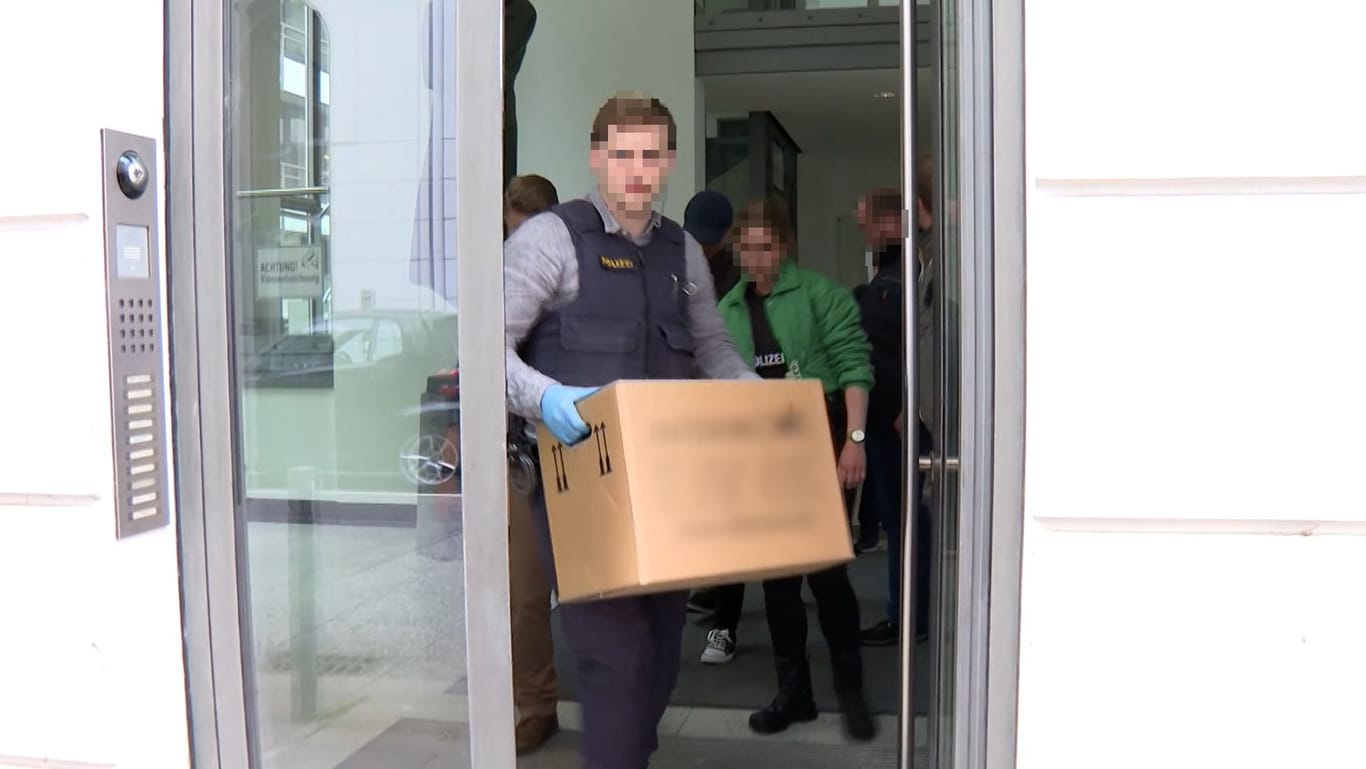 Polizisten tragen einen Karton aus einem durchsuchten Gebäude: In Hamburg ist eine Anwaltskanzlei das Ziel der Ermittler gewesen.
