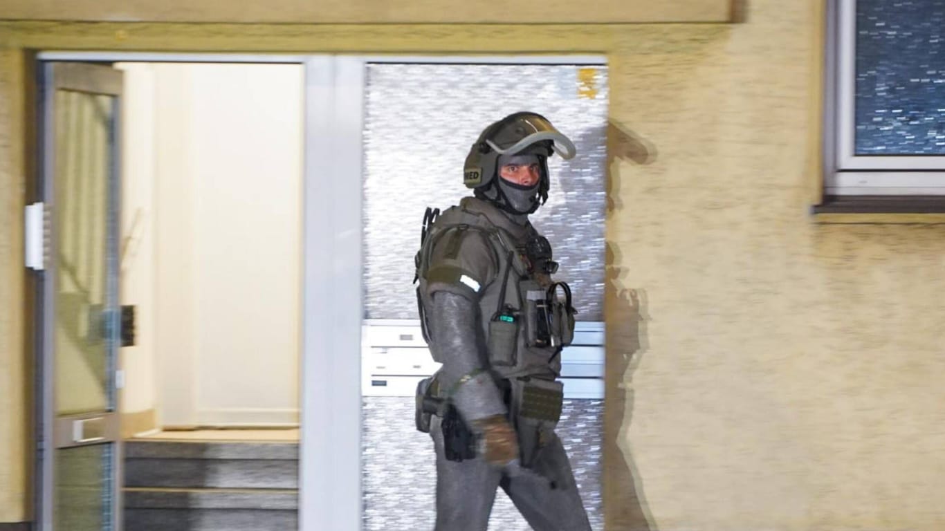 Ein Polizist eines Spezialeinsatzkommandos geht aus einer Haustür (Symbolfoto): Eine junge Frau in Hamburg kam mit dem Schrecken davon.