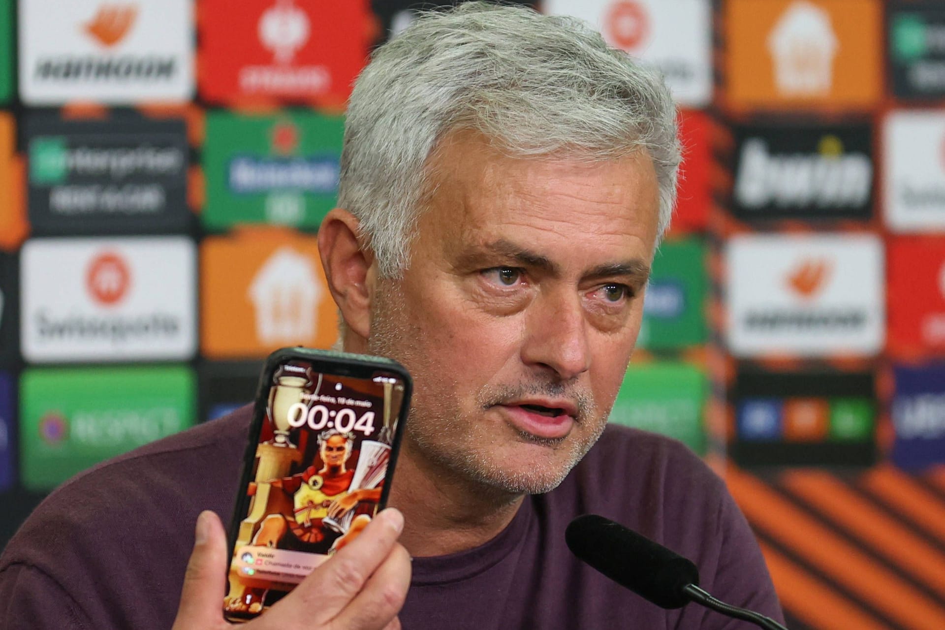 Startrainer José Mourinho zeigt nach dem Spiel in Leverkusen sein Smartphone: auf dem Sperrbildschirm sitzt ein Römer mit Europa League-Pokal.