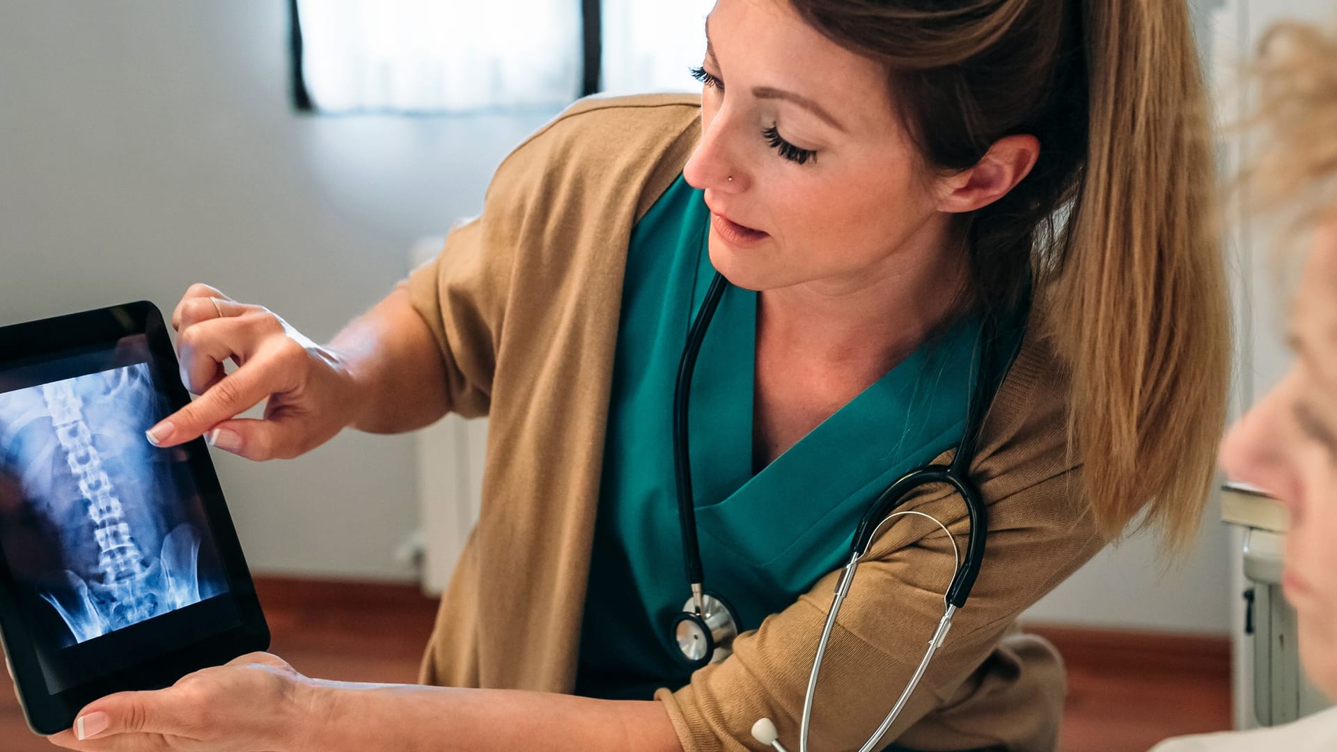 Eine Ärztin bespricht eine Röntgenaufnahme mit einer Patientin: Ob es sich auch ohne blauen Fleck um einen Rippenbruch handelt, kann nur eine ärztliche Untersuchung sicher zeigen.