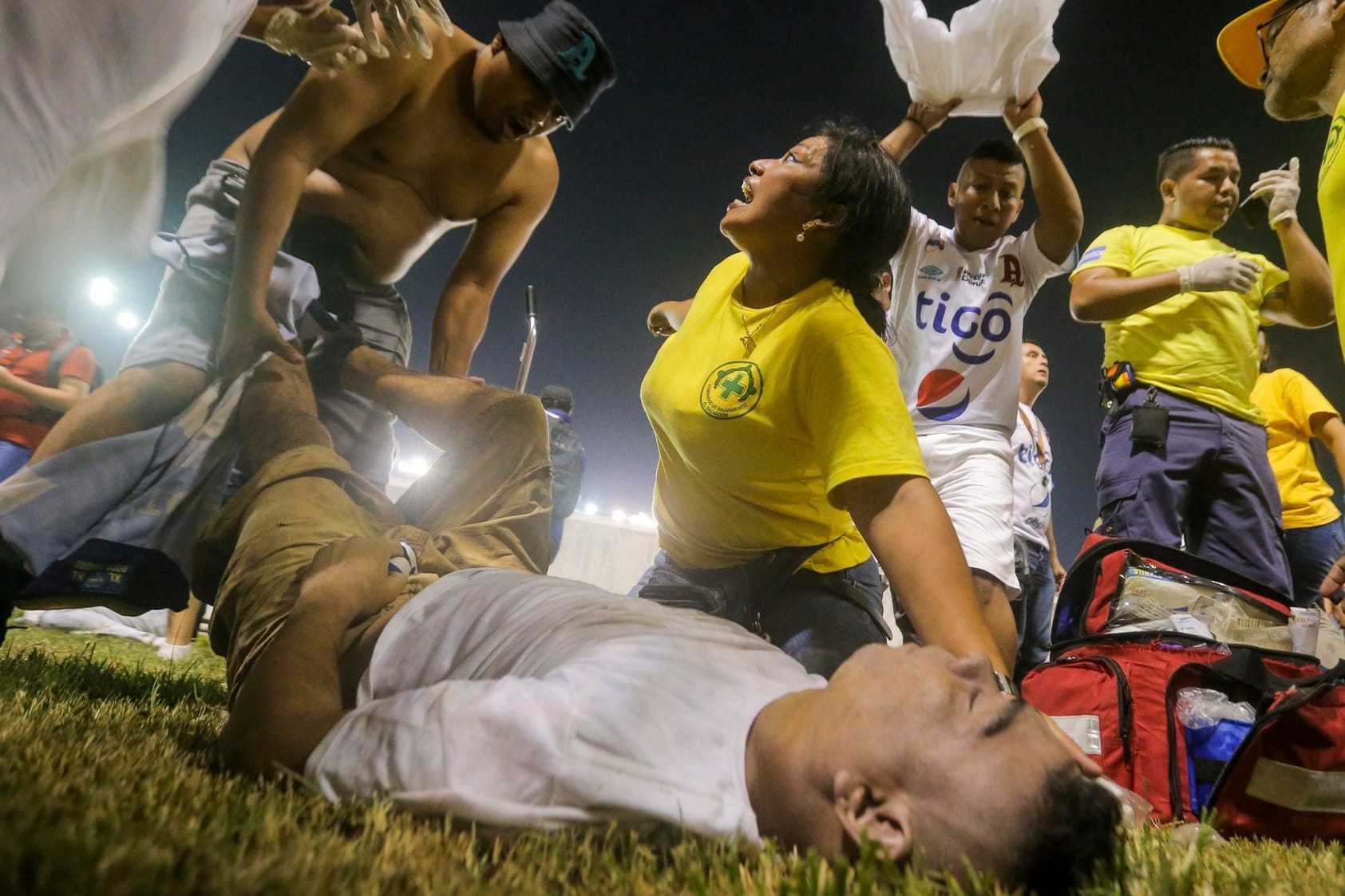 Rettungskräfte kümmern sich um einen verletzten Fan: Bei einer Massenpanik in El Salvador kamen mehrere Menschen ums Leben.