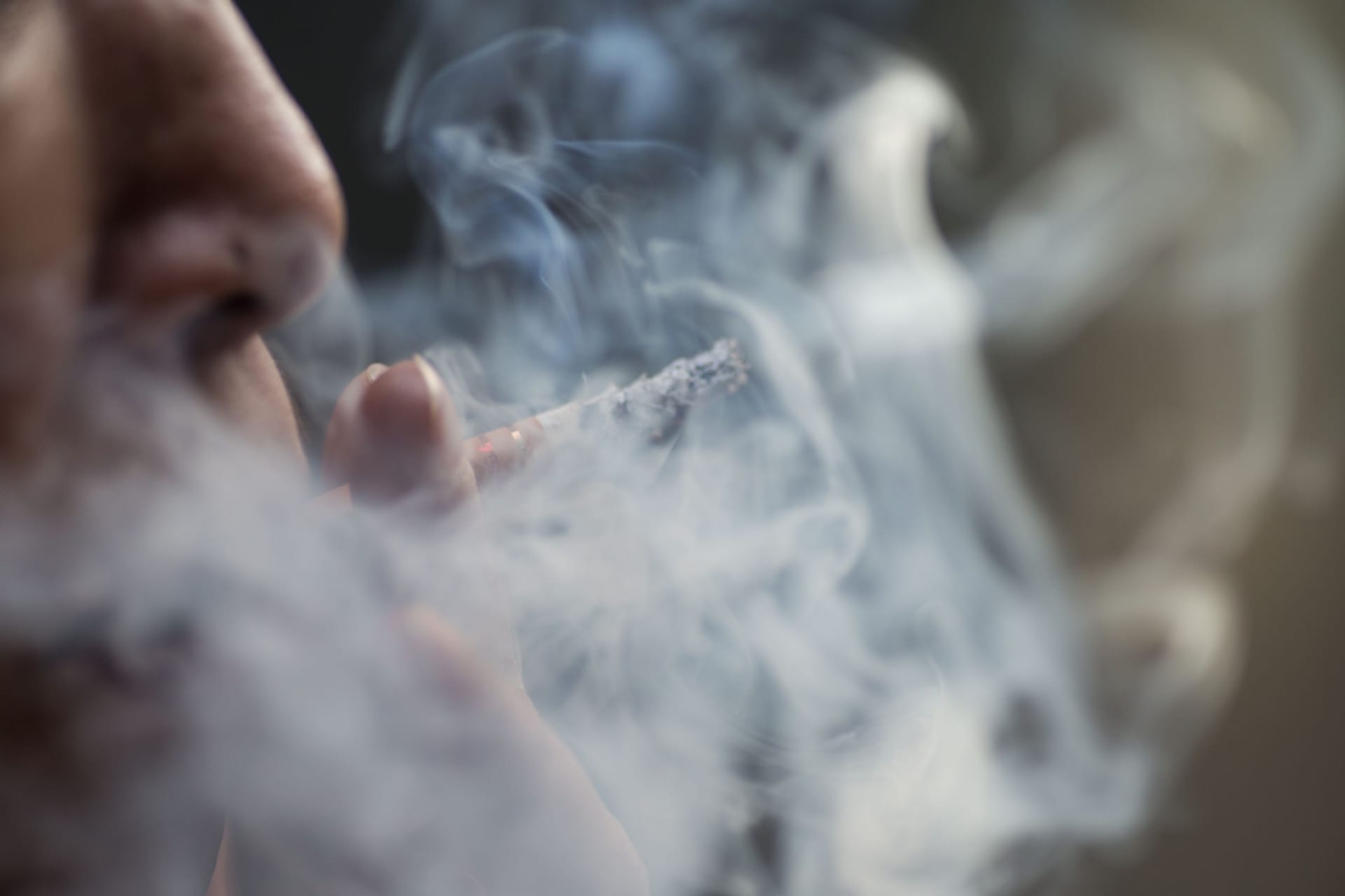 Selective focus shot of a female smoking cigarets - the concept of addiction