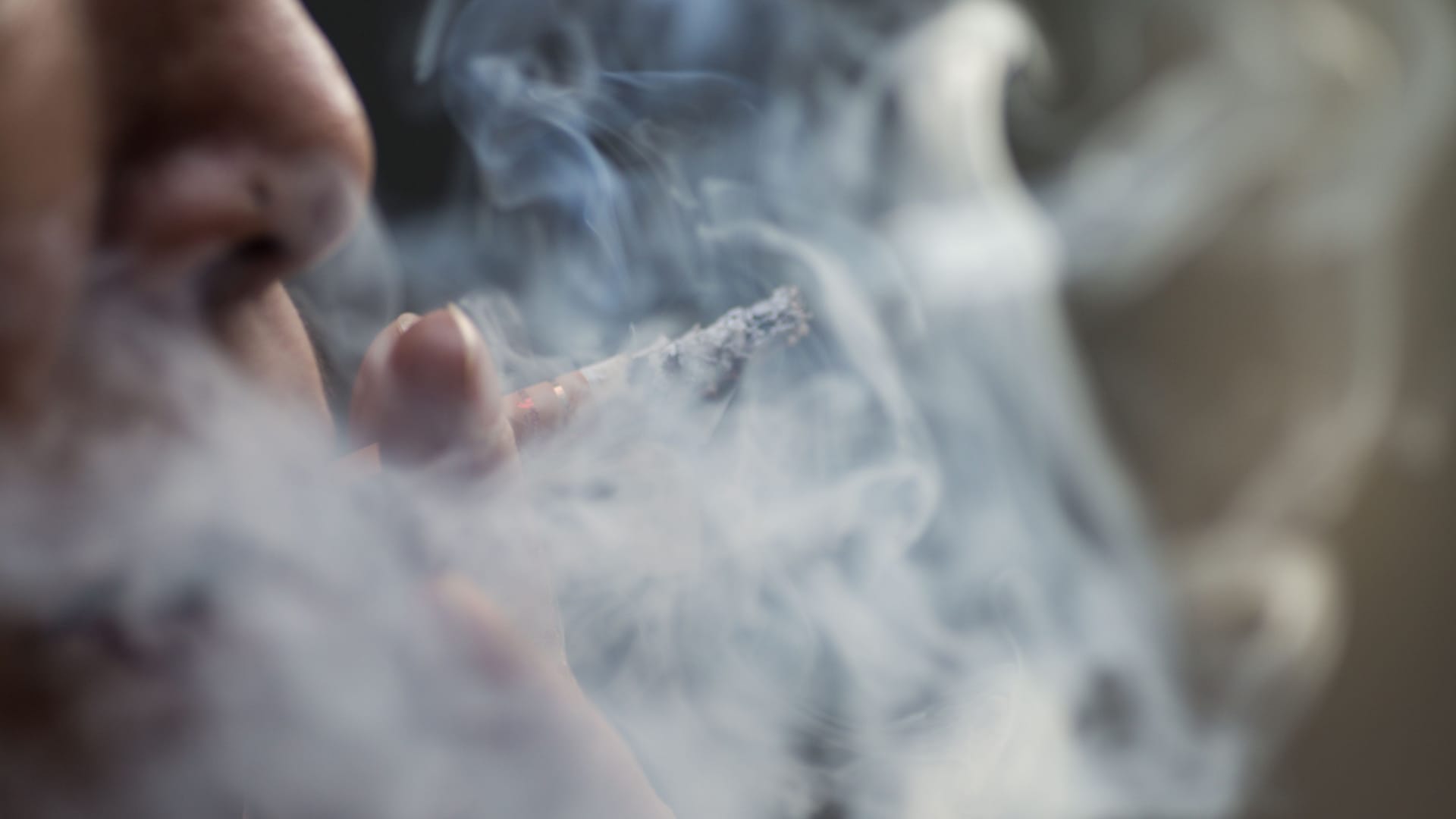 Selective focus shot of a female smoking cigarets - the concept of addiction