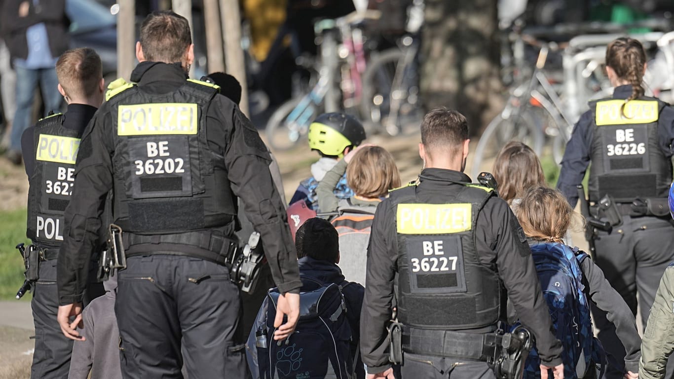Polizisten geleiten Kinder von einer Schule in Neukölln weg: Zwei Schulkinder sind am Mittwoch in einer Schule in Berlin-Neukölln vermutlich von einem Mann verletzt worden.