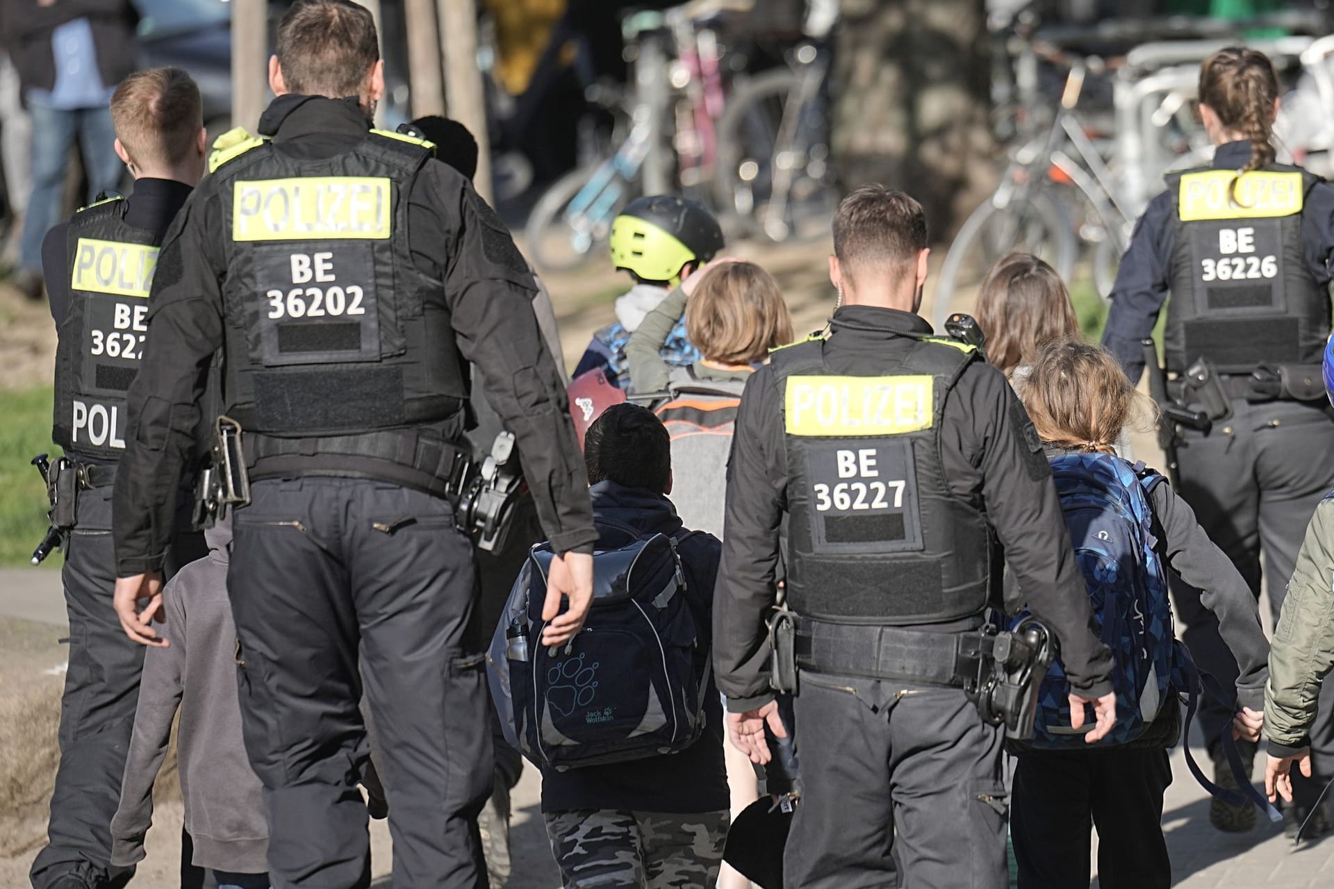 Polizisten geleiten Kinder von einer Schule in Neukölln weg: Zwei Schulkinder sind am Mittwoch in einer Schule in Berlin-Neukölln vermutlich von einem Mann verletzt worden.