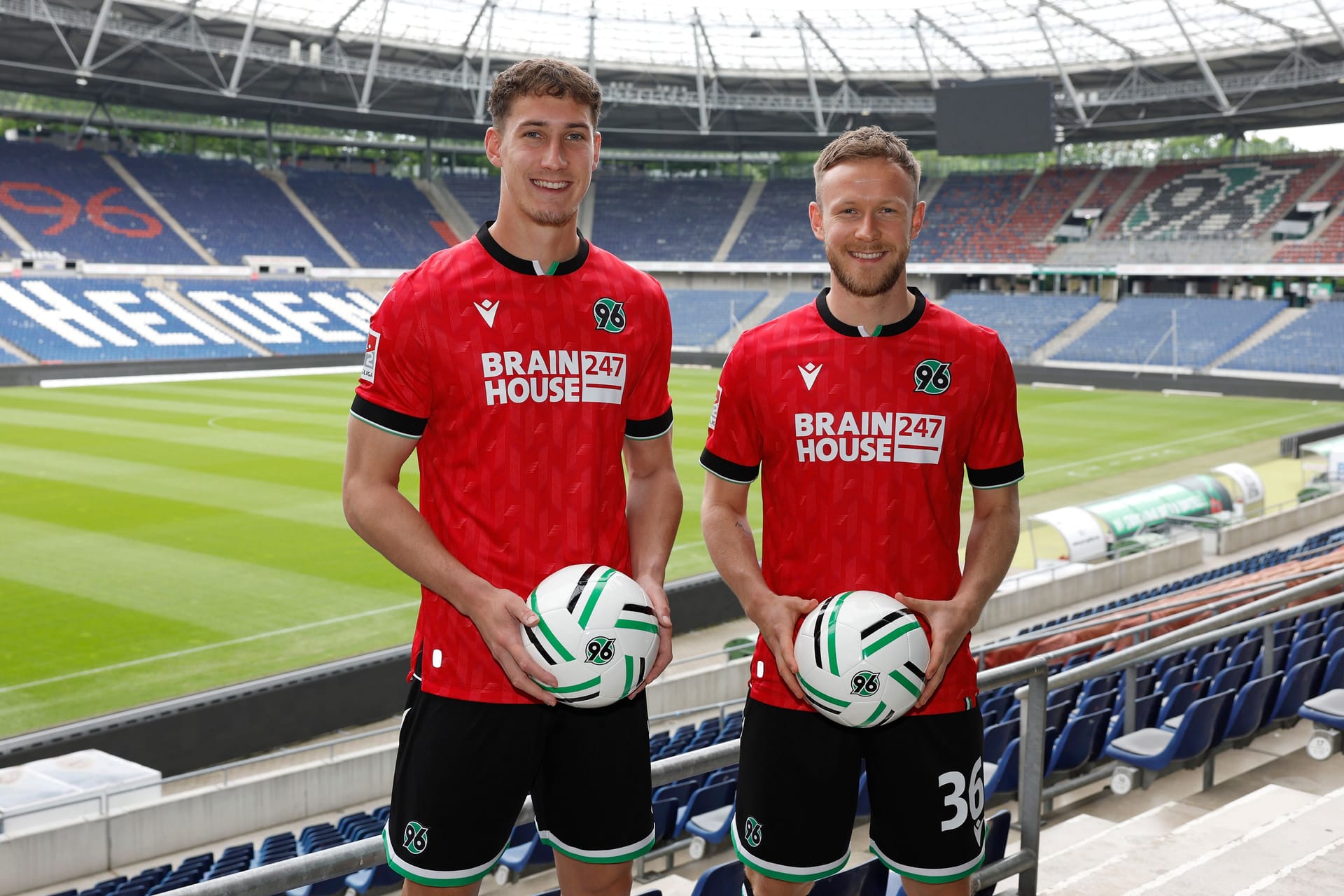 Cedric Teuchert (rechts) und Phil Neumann (links) in der Heinz von Heiden Arena: Die beiden Fußballprofis tragen das neue Heimtrikot von Hannover 96.