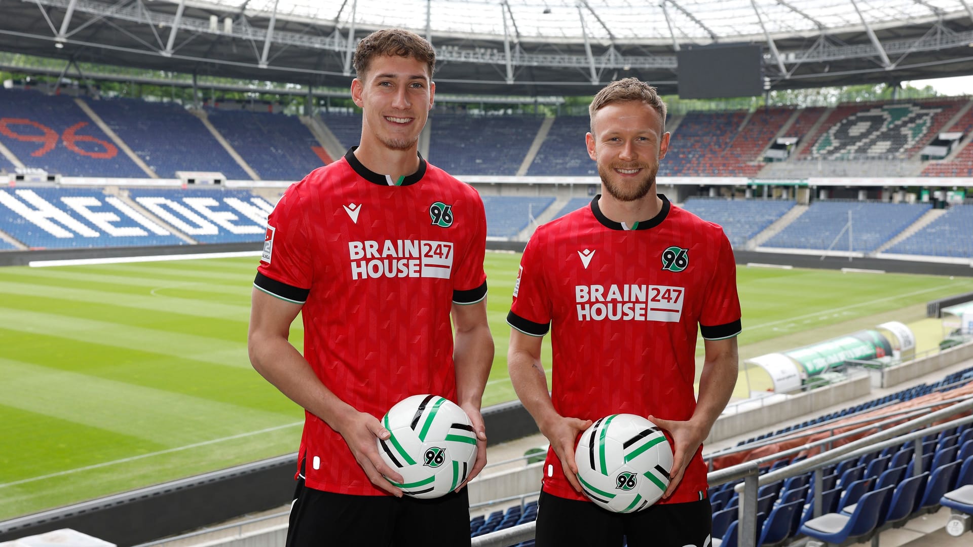 Cedric Teuchert (rechts) und Phil Neumann (links) in der Heinz von Heiden Arena: Die beiden Fußballprofis tragen das neue Heimtrikot von Hannover 96.