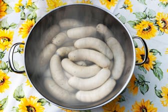 Ein Kochtopf voller Weißwürste in heißem Wasser: Auch, wenn die Currywurst bundesweit beliebter ist, bleibt sie in Bayern geheimer Spitzenreiter.