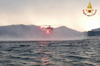 Rettungskräfte suchen per Hubschrauber nach Vermissten, nachdem ein Touristen-Boot auf dem italienischen Lago Maggiore gekentert ist.