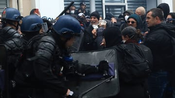 Polizisten geraten am Rande einer Demonstration am Tag der Arbeit mit Demonstranten aneinander.