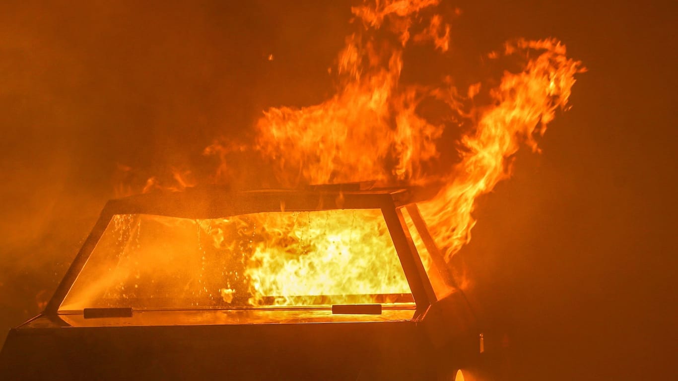 Ein brennendes Auto (Symbolbild): Die Polizei sucht nach Personen, die einen Streifenwagen in Brand gesetzt haben sollen.