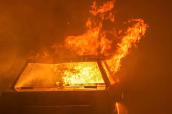 Ein brennendes Auto (Symbolbild): Die Polizei sucht nach Personen, die einen Streifenwagen in Brand gesetzt haben sollen.