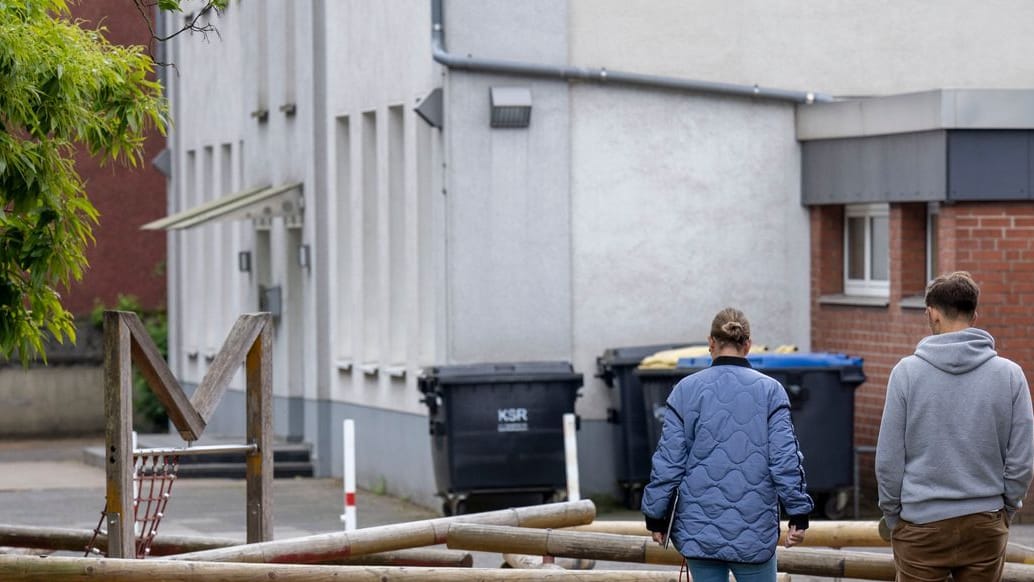 Zwei Beamte der Kriminalpolizei suchen nach Spuren auf dem Schulhof der Grundschule: Die Jugendliche soll stranguliert worden sein.