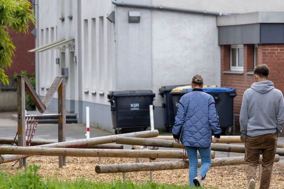 Zwei Beamte der Kriminalpolizei suchen nach Spuren auf dem Schulhof der Grundschule: Die Jugendliche soll stranguliert worden sein.