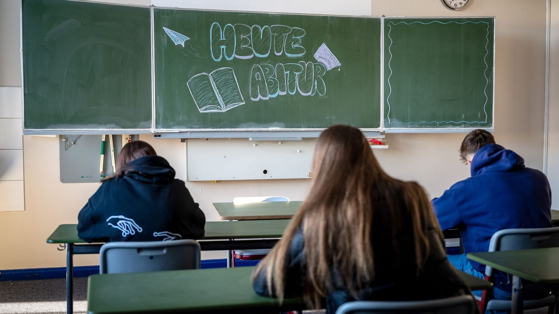 Prüfungen laufen im Klassenzimmer eines Gymnasiums (Symbolbild): Ein Berichtszeugnis hilft Schülern mehr als Noten, findet ein Gewerkschafter.