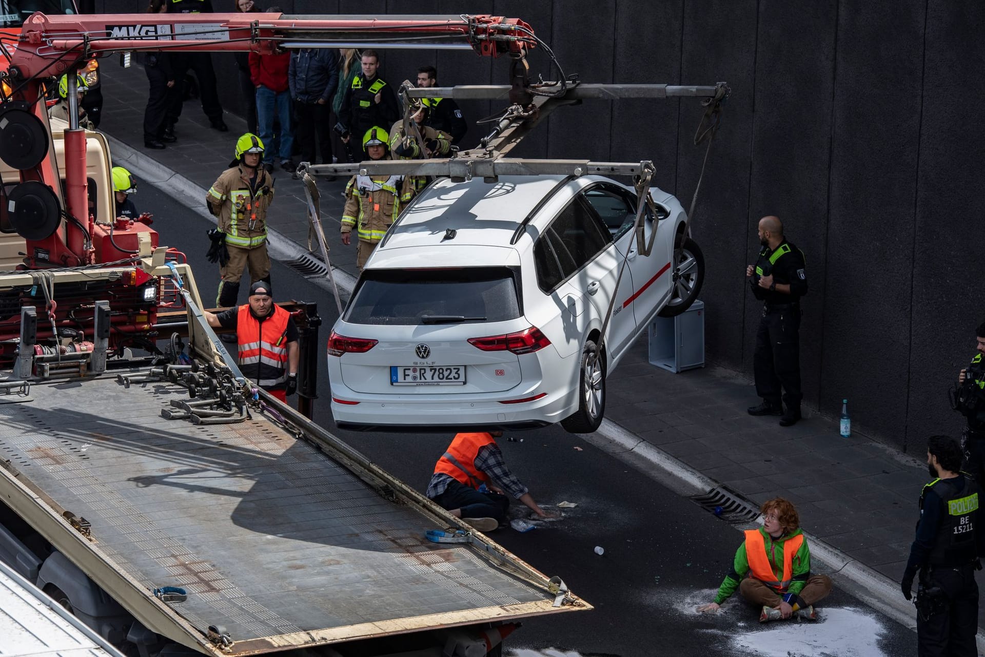 Ein Abschleppwagen transportiert auf der Autobahn 100 einen Wagen ab: Unter ihm hatte sich ein Aktivist auf die Fahrbahn geklebt.