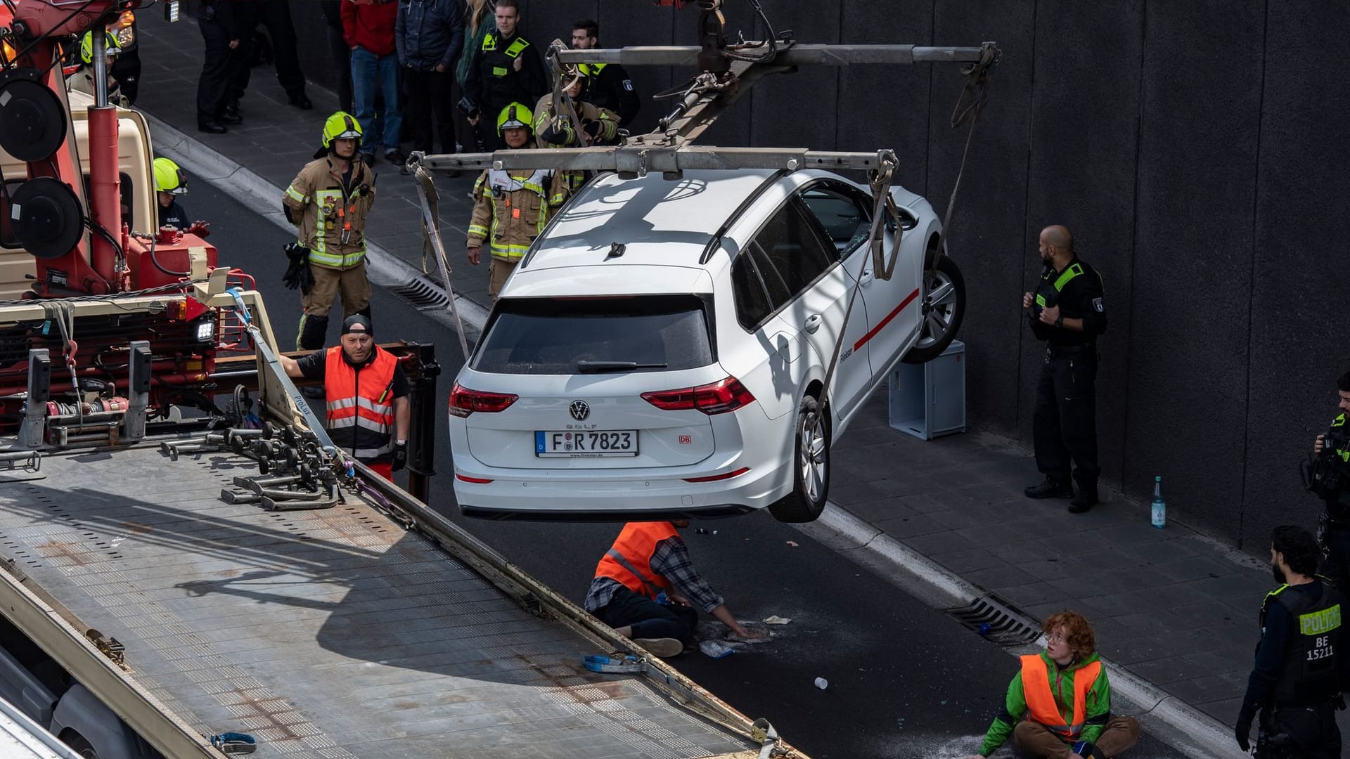 Ein Abschleppwagen transportiert auf der Autobahn 100 einen Wagen ab: Unter ihm hatte sich ein Aktivist auf die Fahrbahn geklebt.