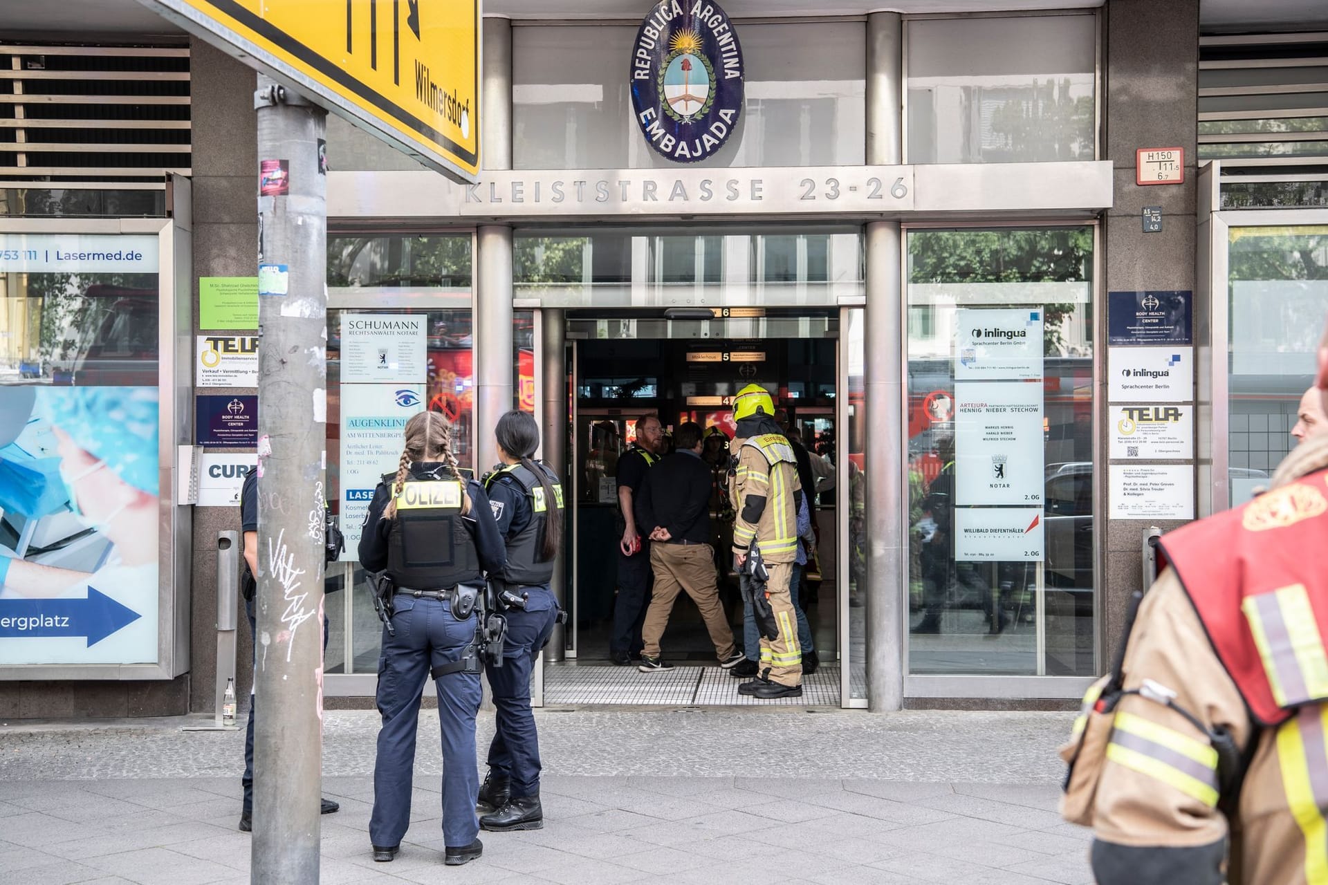 Einsatzkräfte der Feuerwehr und Polizei stehen in einem Hauseingang an der Kleiststraße. In dem mehrgeschossigen Gebäude kam es zu einem tödlichen Unfall mit einem Paternoster.