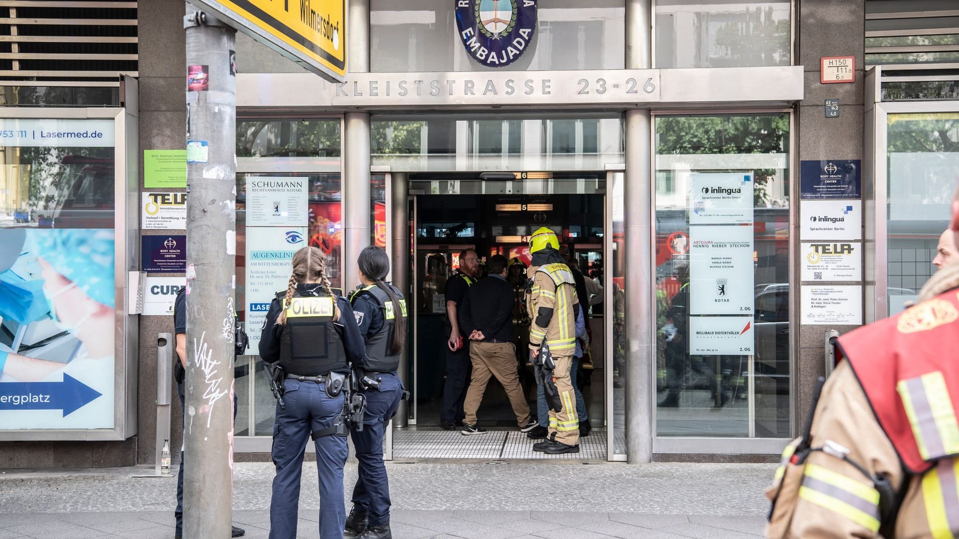 Einsatzkräfte der Feuerwehr und Polizei stehen in einem Hauseingang an der Kleiststraße. In dem mehrgeschossigen Gebäude kam es zu einem tödlichen Unfall mit einem Paternoster.