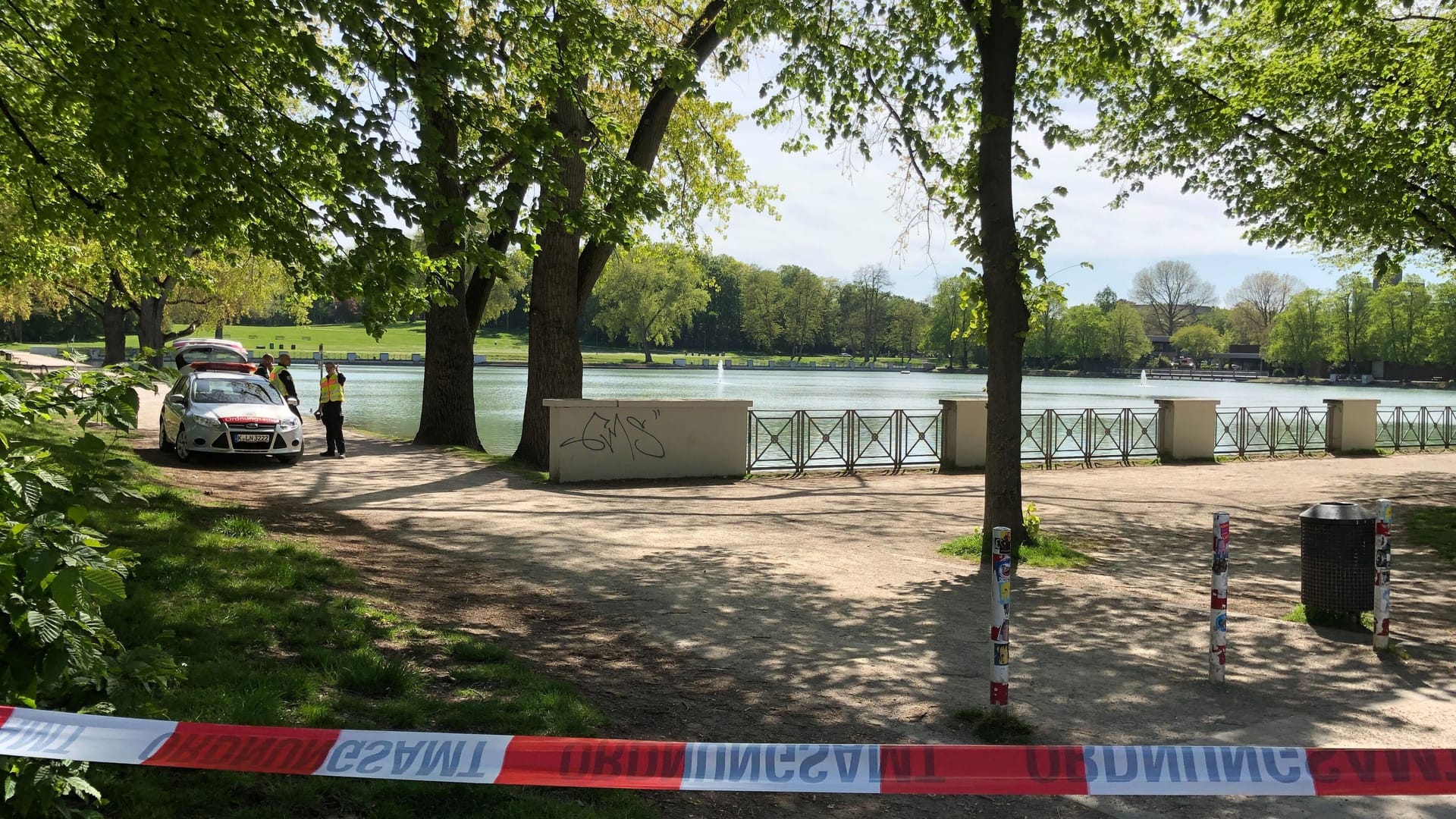 Ein Absperrband am Aachener Weiher: Die Polizei hat den Bereich rund um den Fundort der Bombe weiträumig abgesperrt.