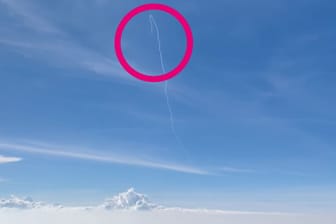 Eine Rakete steigt neben einen Flugzeug auf