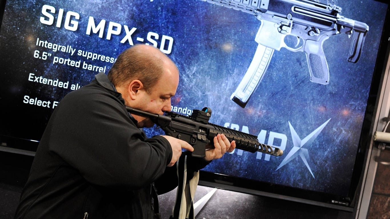 Ein Besucher schaut sich ein Maschinengewehr des deutschen Hersteller Sig Sauer auf einer Messen in den USA an (Symbolbild). Die Bundesregierung will jetzt einen Stand auf einer Ausstellung in Las Vegas aufgeben.