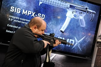 Ein Besucher schaut sich ein Maschinengewehr des deutschen Hersteller Sig Sauer auf einer Messen in den USA an (Symbolbild). Die Bundesregierung will jetzt einen Stand auf einer Ausstellung in Las Vegas aufgeben.