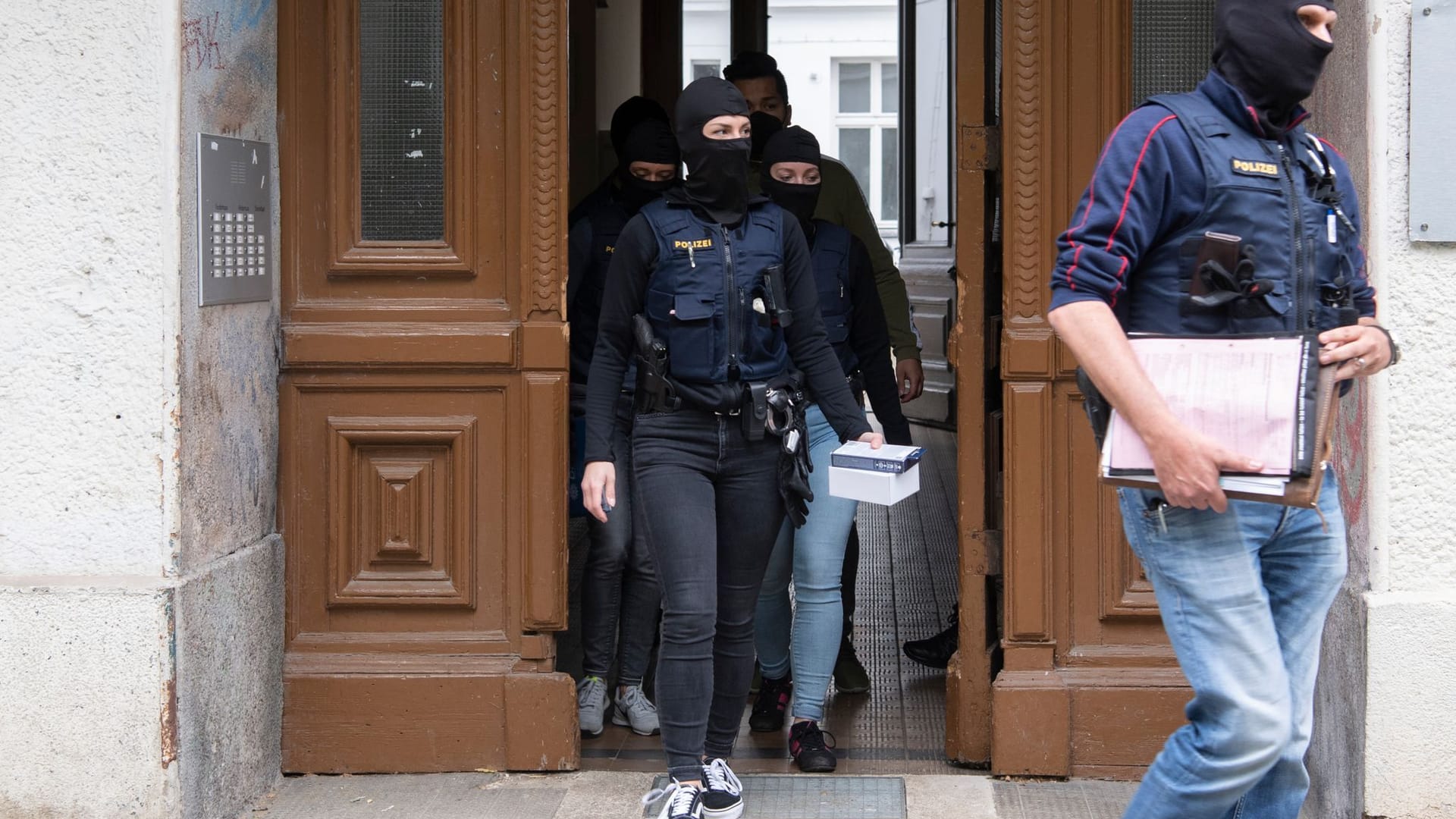 Polizeibeamte verlassen nach der Razzia einer Wohnung der "Letzter Generation" das Haus. Auch das Haus von Carla Hinrichs in Berlin war betroffen.