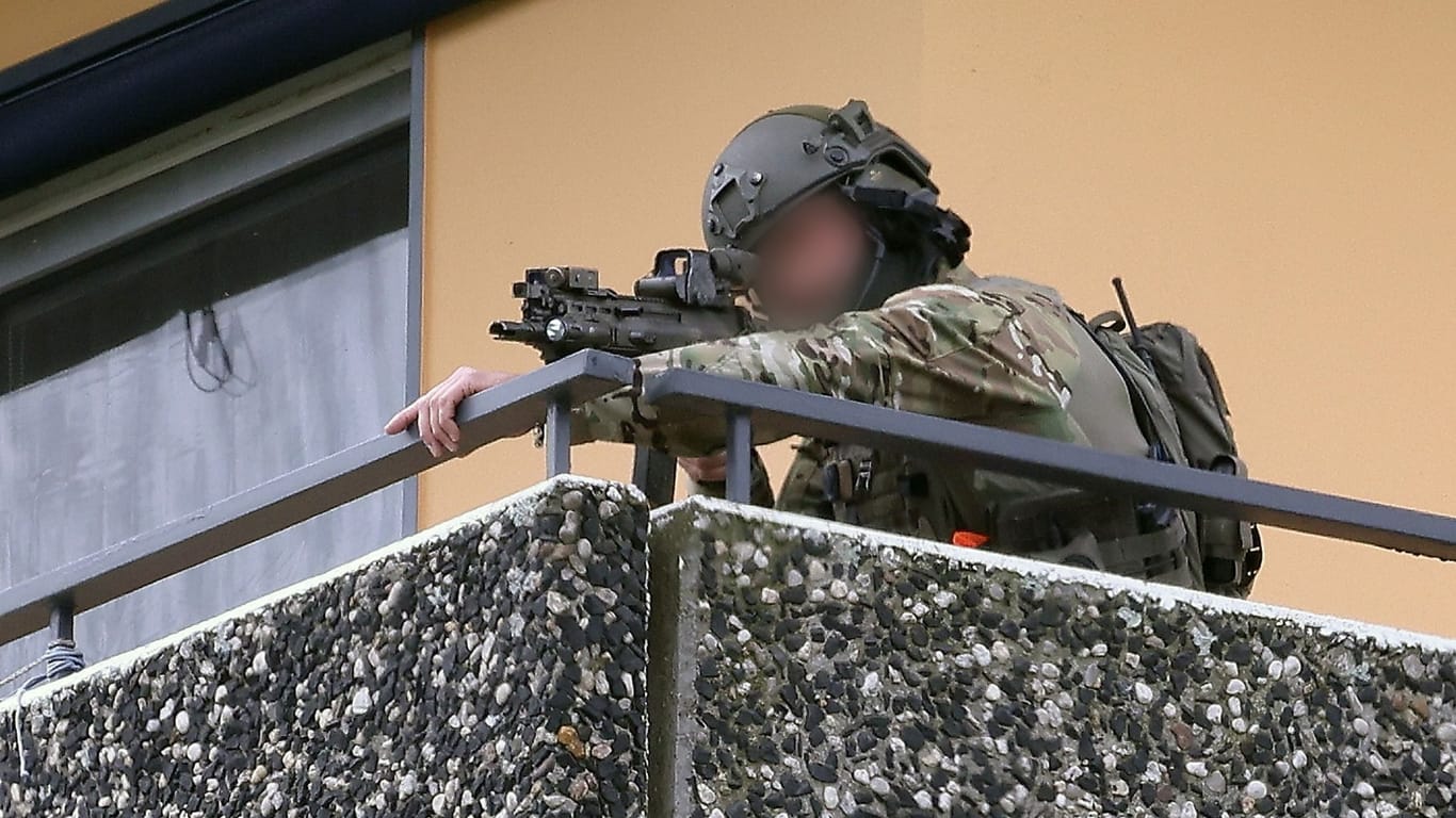 Ein Polizeibeamter in Spezialausrüstung steht auf einem Balkon: In Ratingen wurden Menschen bei einer Explosion verletzt.