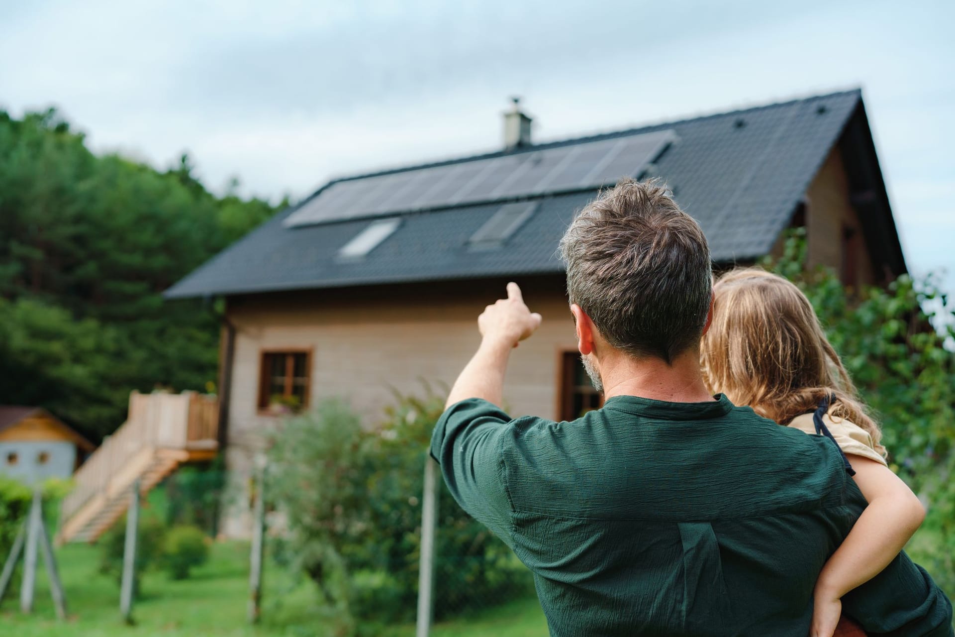 Ein Vater zeigt seiner kleinen Tochter das eigene Haus (Symbolbild): Familien haben es zunehmend schwer, an Wohneigentum zu kommen.