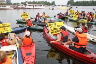 Protestaktion auf der Binnenalster: Vor dem Weltflüchtlingstag am Dienstag demonstrieren Mitglieder von Greenpeace und Fridays for Future mit Kajaks, Schlauchbooten und Bannern auf der Binnenalster in Hamburg.