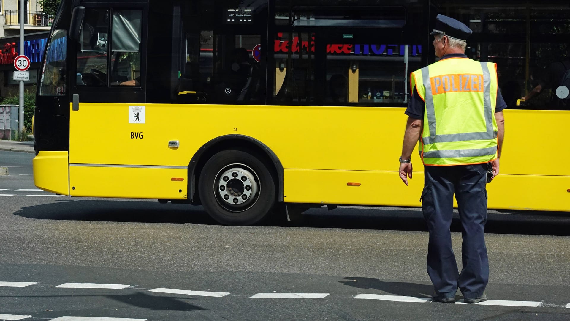 Polizist auf Straße vor BVG-Bus (Symbolbild): In Marzahn wurde ein Mann fremdenfeindlich angegriffen.