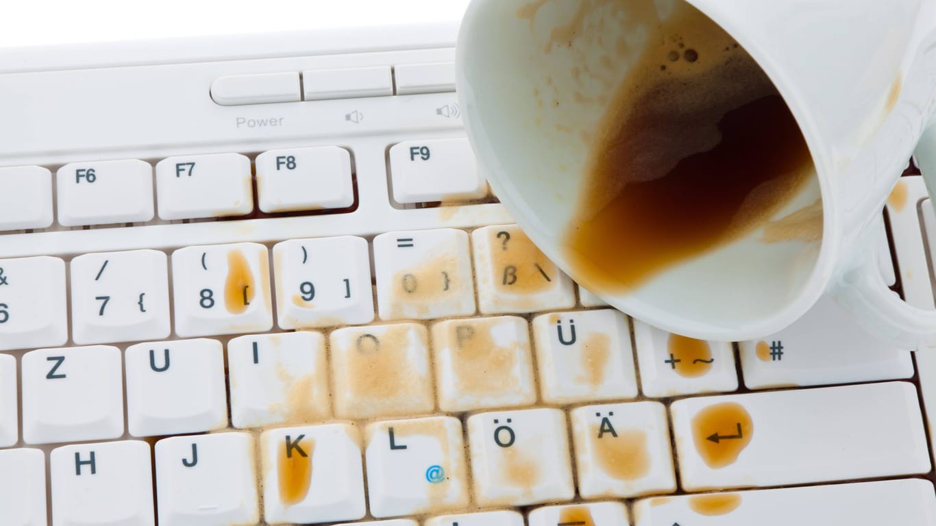 Verschütteter Kaffee beschädigt eine Tastatur: Eine Haftpflichtversicherung kann Sie vor hohen Kosten bewahren.