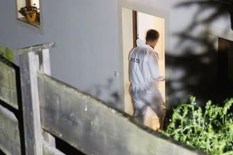 Ein Beamter der Spurensicherung: Er betritt ein Wohnhaus, nachdem die Polizei drei Leichen in dem abgelegenen Haus entdeckt hat.