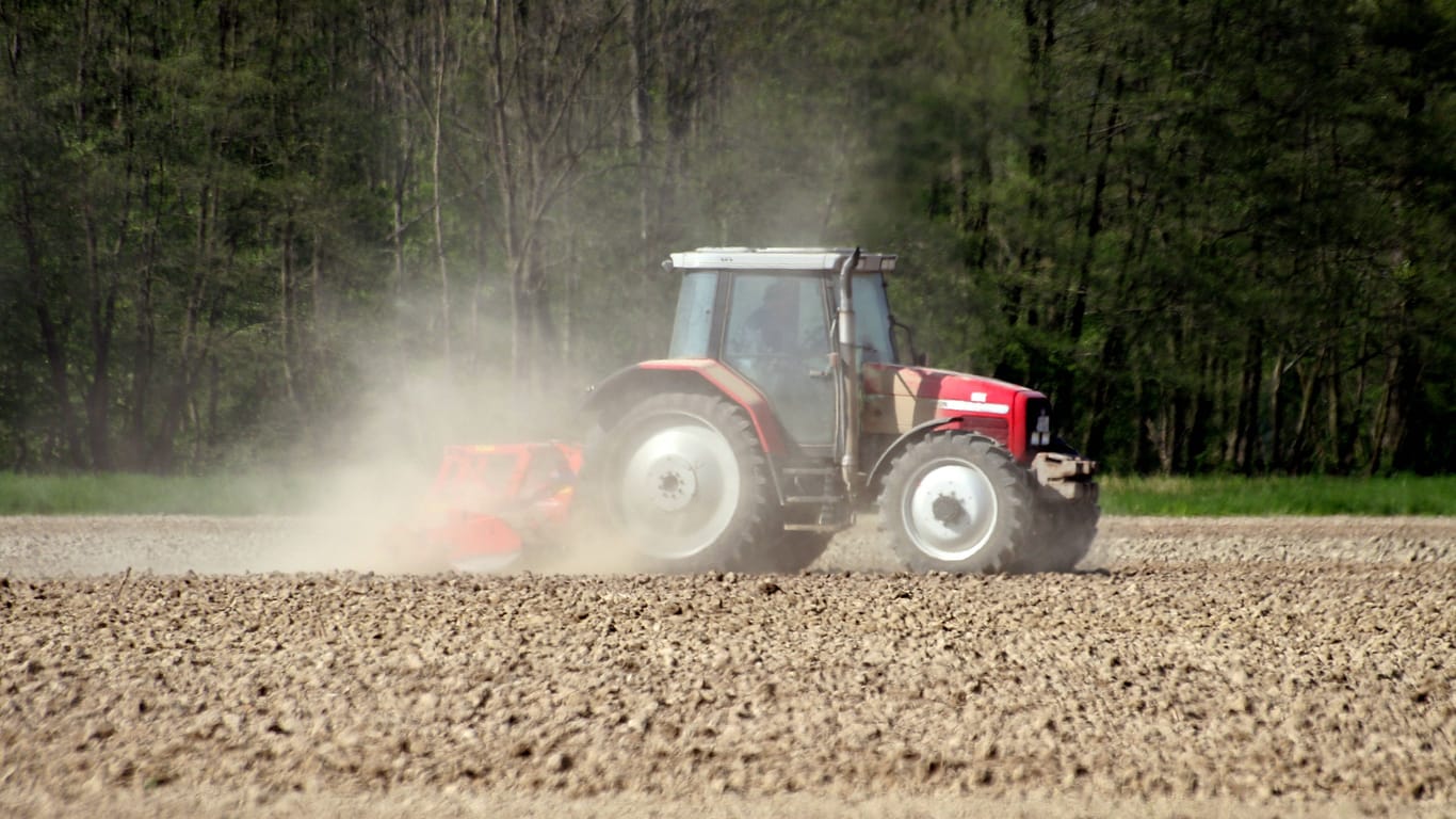 Traktor auf einem Acker bei der Bodenbearbeitung in einer Staubwolke (Symbolbild): Niedersachsens Felder leiden unter der Hitzewelle.