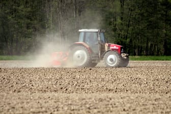 Traktor auf einem Acker bei der Bodenbearbeitung in einer Staubwolke (Symbolbild): Niedersachsens Felder leiden unter der Hitzewelle.