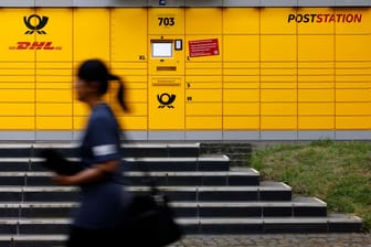 Eine Frau läuft an einer Poststation vorbei: Die Deutsche Post will verstärkt eine andere Automatenart in Betrieb nehmen.