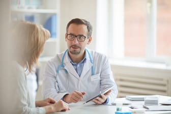 Ein Arzt im Gespräch mit einer Patientin