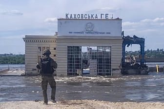 Ein Offizier eines russischen "Investigativkommittees" vor dem überfluteten Wasserkraftwerk in Kachowka: Eine tatsächliche Untersuchung des Vorfalls hat der Kreml untersagt. Auch UN-Inspekteure durften bisher nicht auf das Staudamm-Gelände.