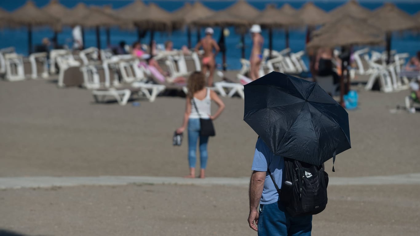 Ein Mann schützt sich vor der Sonne am Strand von Malaga, Spanien: Bereits Ende April erfuhr das Land eine Hitzewelle von bis zu 35 Grad. Jetzt sind es nochmals knapp 10 Grad mehr.